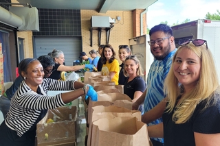 Yale employees helping the United Way of Greater New Haven pack and distribute over 1,200 grocery bags for local families in need.